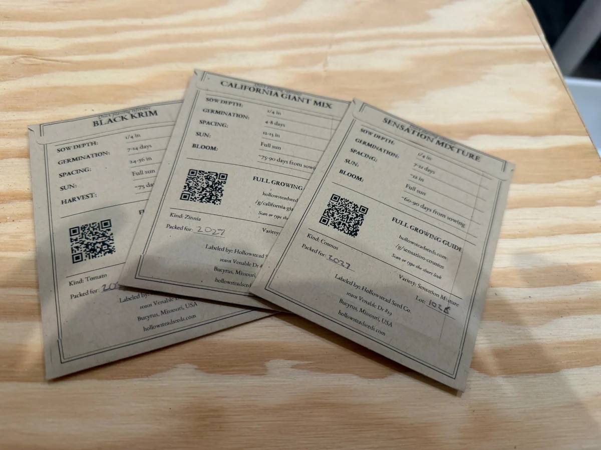 Backs of Hollowstead seed packets showing printed growing instructions, QR codes, and handwritten packed-for dates.